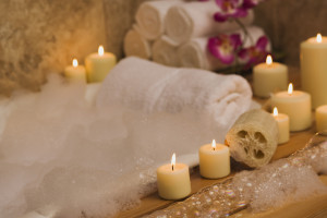 Apartments in Jersey Village A tranquil bath tub adorned with delicate flowers and flickering candles, accompanied by luxuriously scented soap.