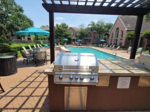 Apartments in Jersey Village, TX - Outdoor Grilling Area with View to Pool and Patio